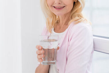 portrait of pretty mature woman holding a glass of water